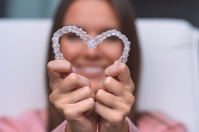 Woman with dental invisible invisalign braces or silicone trainer. Aligners treatment Woman with dental invisible invisalign braces or silicone trainer. Aligners treatment