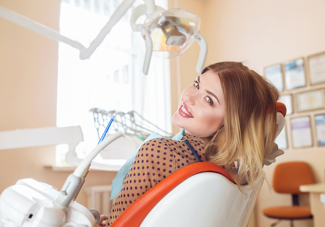 Beautiful Woman smile close up. Healthy Smile. Beautiful Female Smile . Orthodontic Treatment. Dental care Concept. Alignment of teeth Woman smiling while sitting in a dental chair at Tampa Palms Dentistry during a cosmetic dentistry consultation